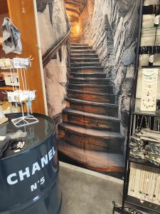 un tonneau en fer avec une montée d'escaliers en trompe oeil