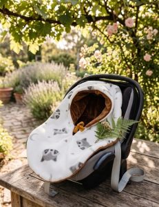cape réversible osée sur un cosy,blanche avec des ratons laveaur