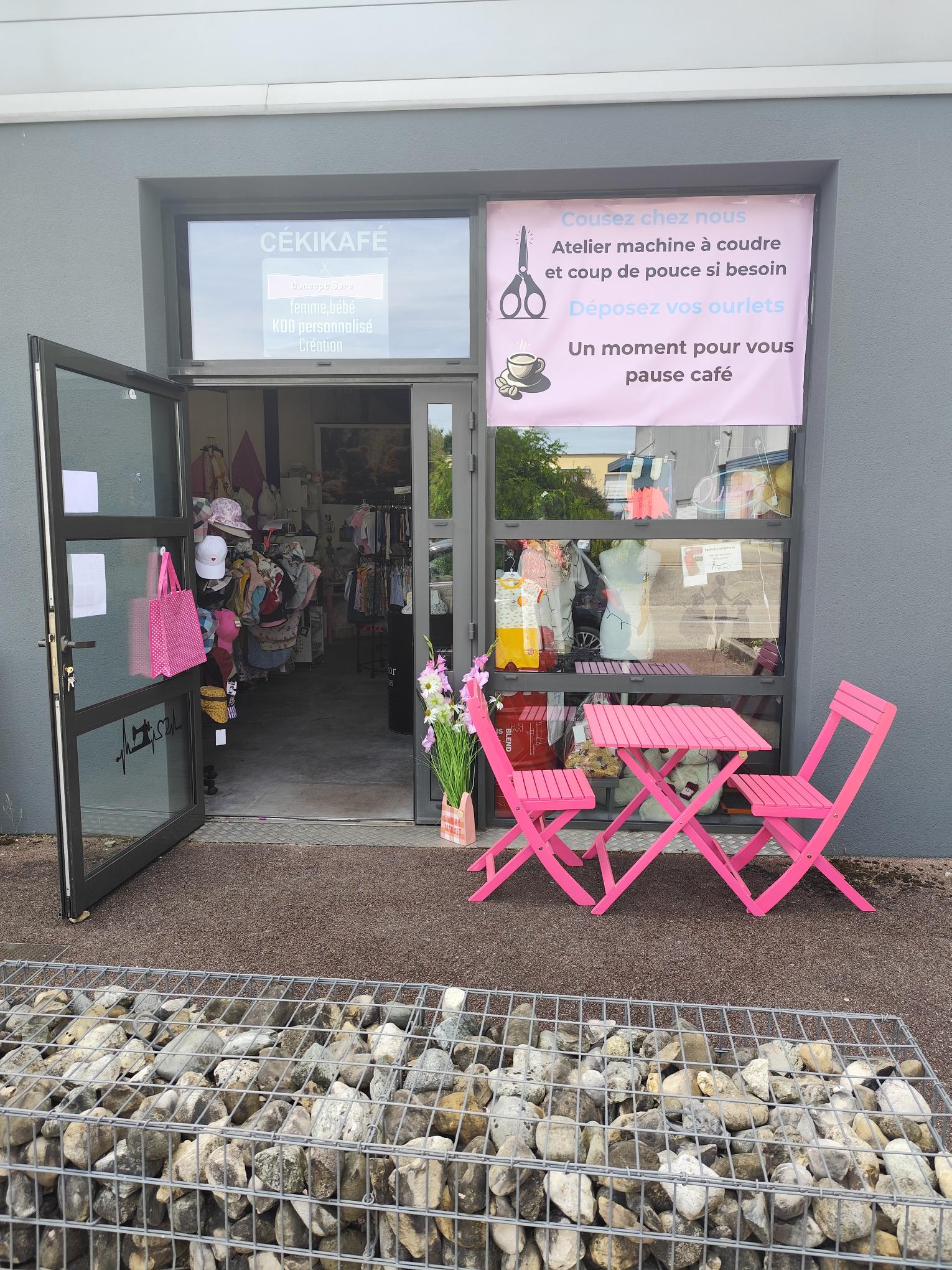 photo de la devanture avec une table rose et deux chaise