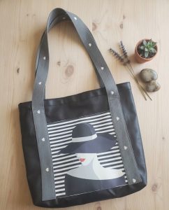 une femme avec un chapeau cousu sur n sac en simili cuir