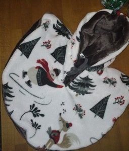 cape réversible en polaire ,motif l'ours qui fait du patin et il y a des sapin et décor d'hiver