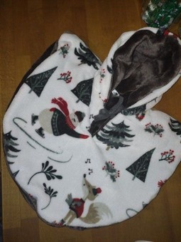 cape réversible en polaire ,motif l'ours qui fait du patin et il y a des sapin et décor d'hiver