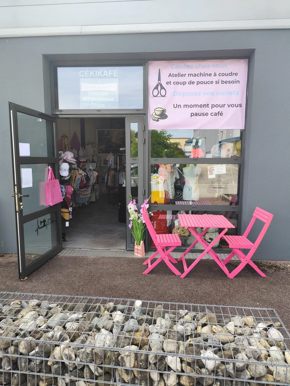 photo de la devanture avec une table rose et deux chaise