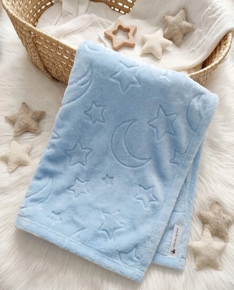couverture bleu e en polaire.Elle a des motifs de la même couleur que la couverture,étoile et lune