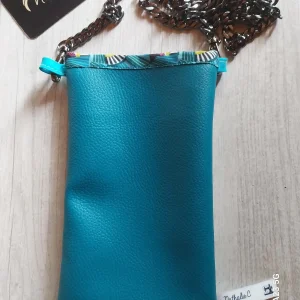 Sur la photo un sac téléphone en simili cuir skai bleu. La bandoulière est une chaine de couleur grise maron.