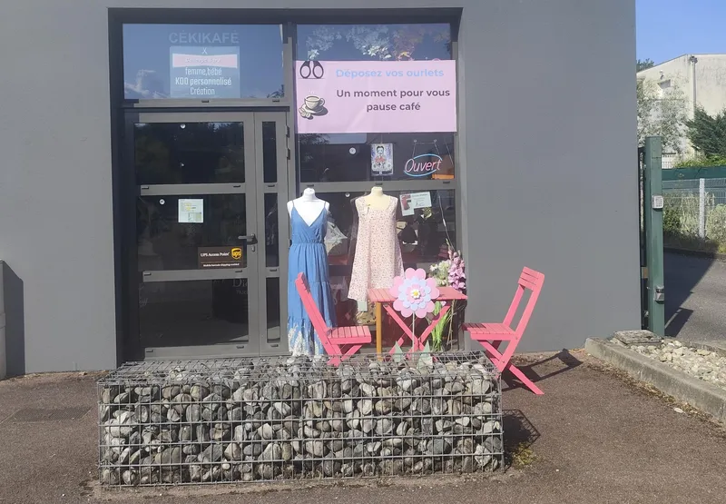 photo de la devanture avec une table rose et deux chaise