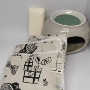 Lingettes lavables posées sur une able et le motif est: la parisienne.une femme en noire avec un grand chapeau noir.